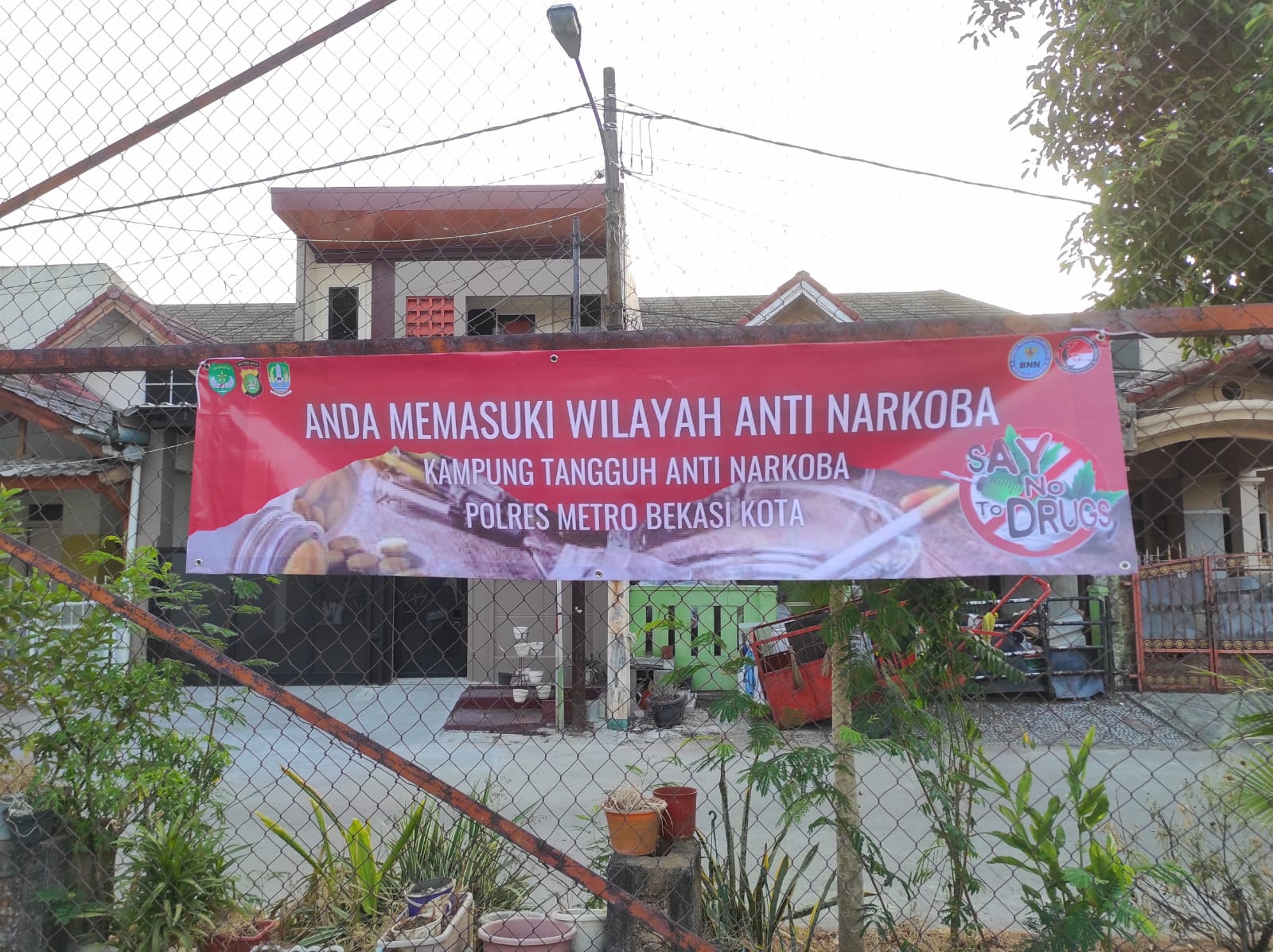 Kolaborasi Satresnarkoba Polres Metro Bekasi Kota dan Satgas Anti Narkoba Pasang Spanduk dan Tempelkan Stiker Call Center Layanan Pengaduan di Lingkungan Kampung Tangguh Anti Narkoba RW 26 Pejuang